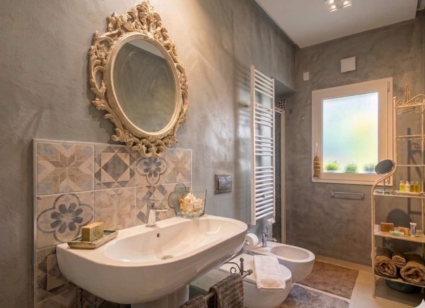 Bagno principale con maioliche siciliane e specchio dorato