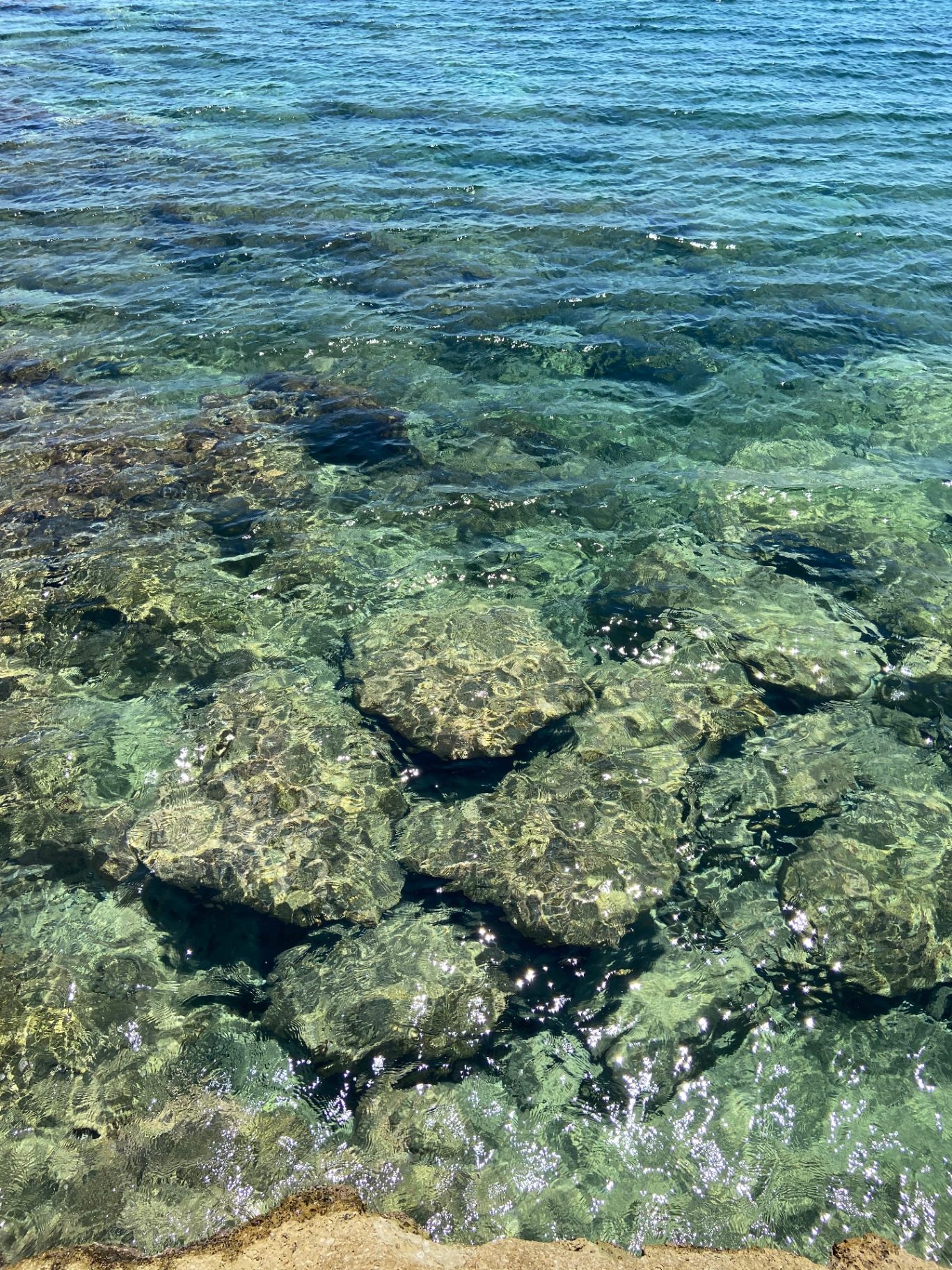 Pietre bianche sommerse nell'acqua limpida del mare siciliano