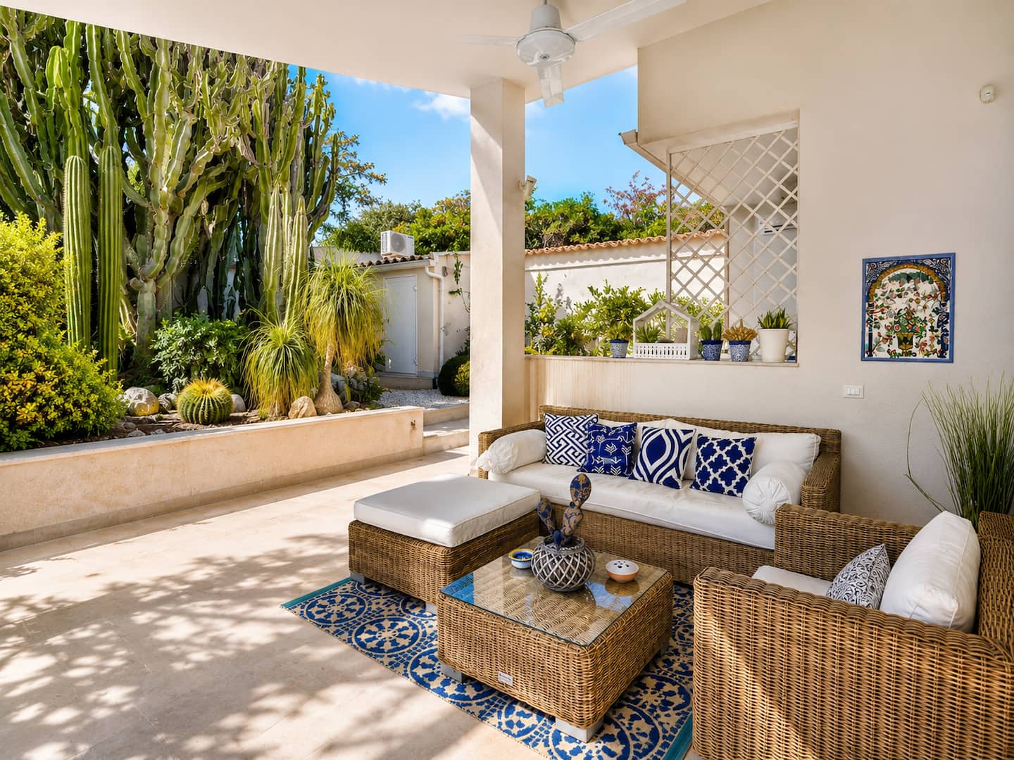 Veranda con divani in vimini affacciata sul giardino